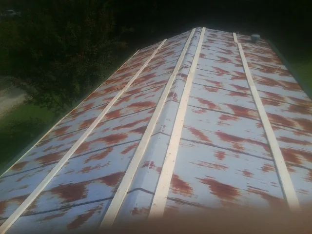 Rusted metal roof panels with new wood purlins before replacement — Storm Damage Roof Repair in Converse by Roofing Brothers