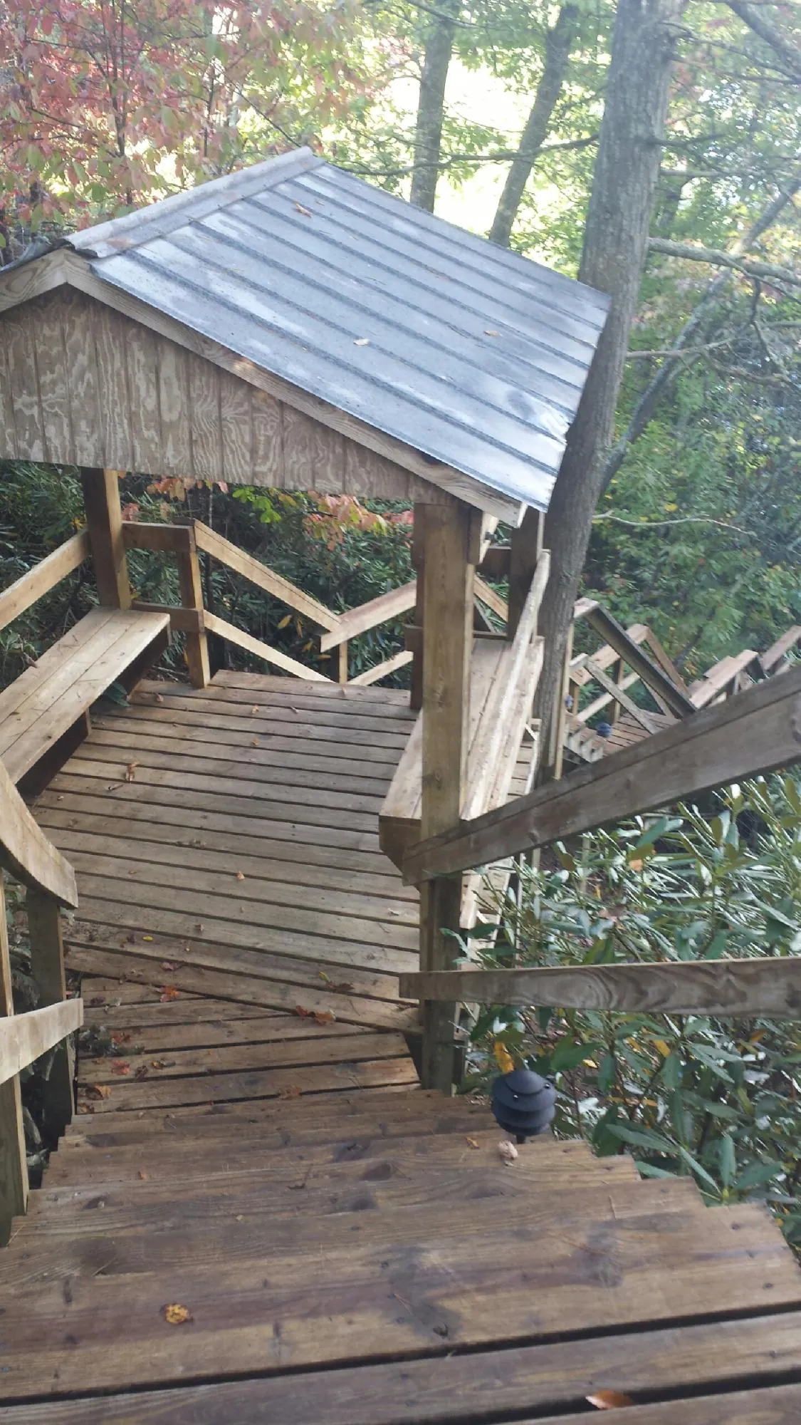 Metal roofed shelter over wooden steps on a wooded walkway — Skylight Repair & Installation work by our crew in Converse