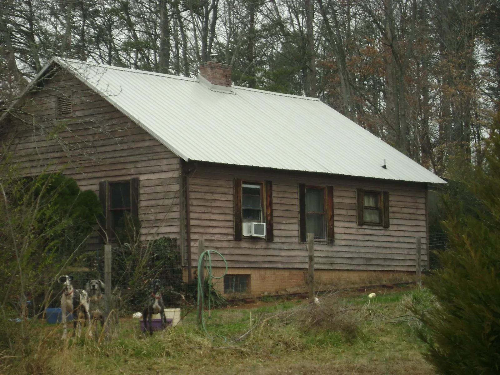 White metal roof on an old wood sided farmhouse, from a Metal Roof Installation job in Converse